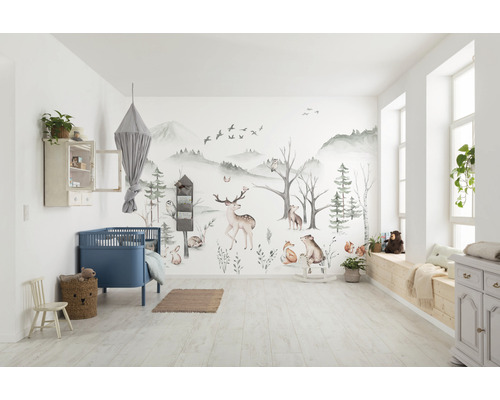 Hell gestaltetes Kinderzimmer mit Waldtapete, blauem Gitterbett und Holzmöbeln