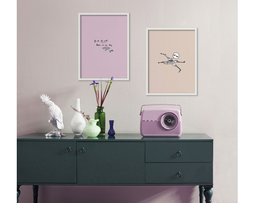Intérieur décoratif avec commode, deux tableaux encadrés et une radio