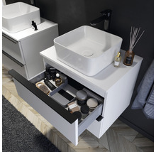 Salle de bains avec vasque à poser sur un meuble sous-lavabo blanc avec tiroir ouvert pour ranger les articles de salle de bains