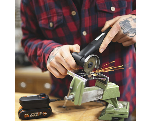 Meuleuse d''angle à batterie en cours d''utilisation avec un étau et une pièce métallique