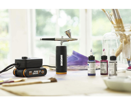 Logo Worx sur aérographe avec batterie et peintures sur une table