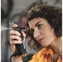 Frau benutzt eine Farbspritzpistole der Marke Worx