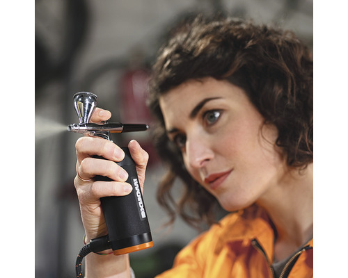 Femme utilisant un pistolet de pulvérisation de peinture de la marque Worx