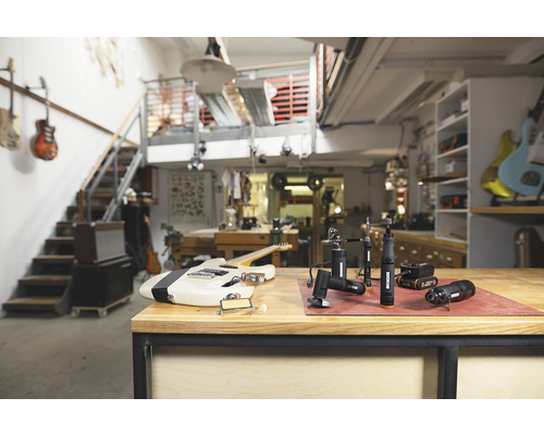 Scène d''atelier avec une guitare électrique et plusieurs outils rotatifs de la marque Worx