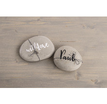 Deux pierres avec inscription et cordon sur une table en bois.