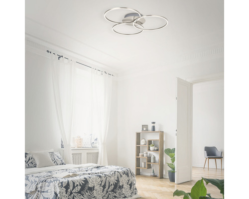 Helles Schlafzimmer mit Bett und runder Deckenleuchte