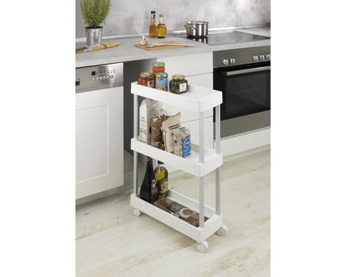 Küchenszene mit einem schmalen, weißen Küchenwagen auf Rollen, der mit Lebensmitteln gefüllt ist.