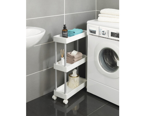 Badezimmer mit einem Waschbecken, einer Waschmaschine und einem Rollwagen mit drei Ablagen zur Aufbewahrung von Badutensilien.