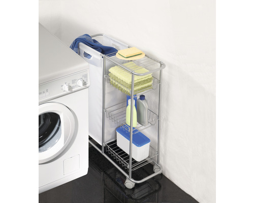 Chariot à linge avec panier à linge, serviettes et produits de nettoyage à côté d''une machine à laver.