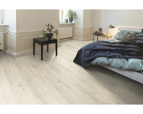 Sol stratifié clair dans une chambre avec lit et table de chevet