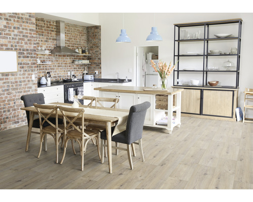 Cuisine lumineuse avec table à manger, îlot de cuisine, mur en briques et étagères