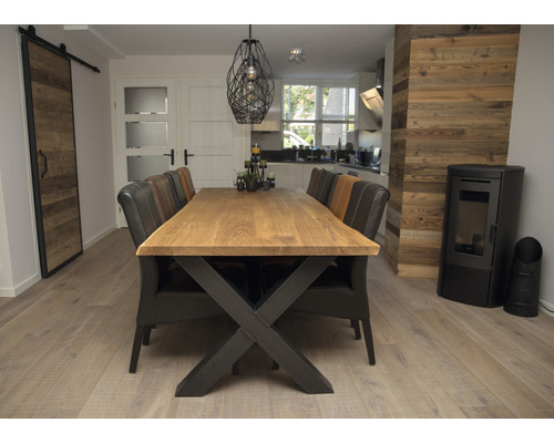 Salle à manger avec table à manger en bois, chaises, porte coulissante et poêle à bois.