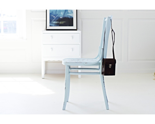 Holzstuhl mit brauner Tasche im hellen Raum