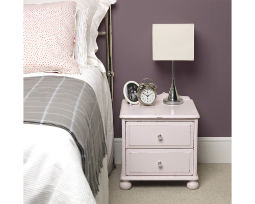 Schlafzimmerszene mit Nachttisch, Lampe und Bett