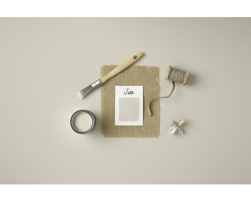 Pot de peinture, pinceau, bobine de fil et échantillon de couleur sur fond de jute