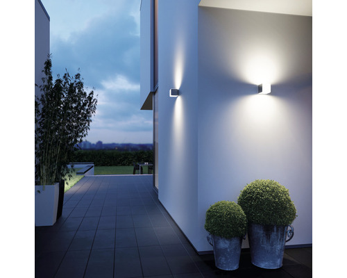 Moderne Hausfassade mit zwei quadratischen Wandleuchten, die warmes Licht ausstrahlen