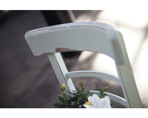 Vue détaillée du dossier d''une chaise en bois avec décoration florale