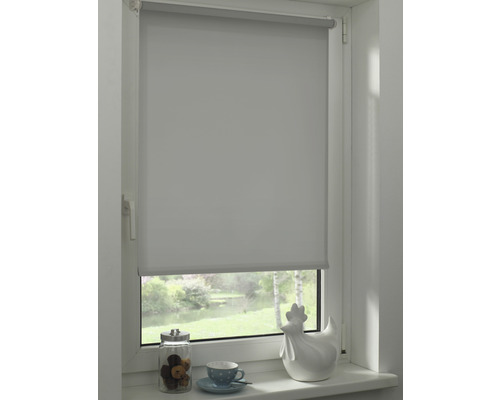 Vue d''une fenêtre avec un store enrouleur gris partiellement abaissé