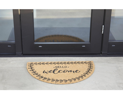 Paillasson demi-lune avec l''inscription ''Hello welcome'' devant une porte.