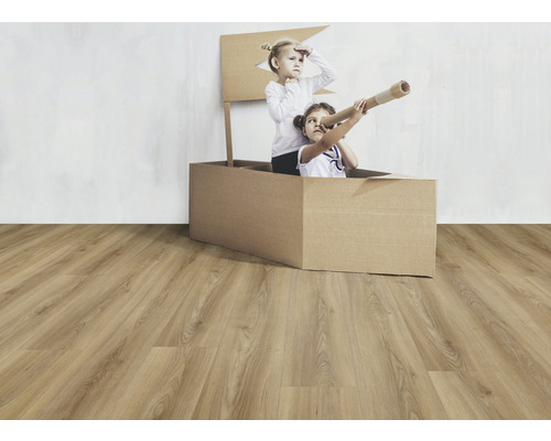 Zwei Kinder spielen in einem Pappkarton auf einem Laminatboden.