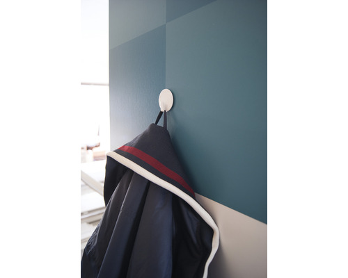 Veste accrochée à un crochet mural rond.