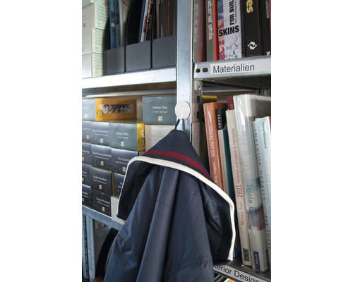 Veste accrochée à un crochet dans une bibliothèque avec des livres et des classeurs.