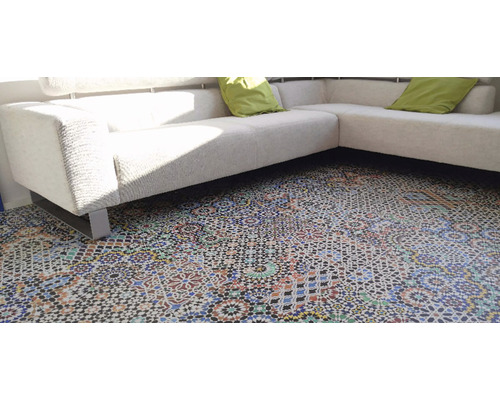 Detailaufnahme eines Zimmers mit einem Sofa und einem Boden mit Musterfliesen