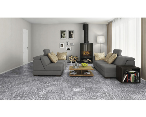 Wohnzimmer mit grauem Bodenbelag im Patchwork-Design, Sofas, Kamin und Holzmöbeln