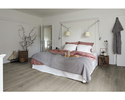 Chambre claire avec lit, table de chevet et plancher en bois
