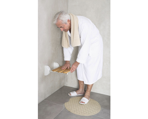 Mann im Bad mit Duschsitz und Badematte