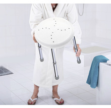 Femme en peignoir tenant un tabouret de douche avec des pieds réglables en hauteur