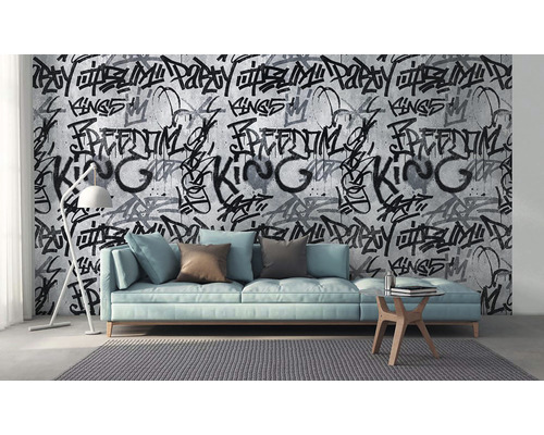 Salon avec canapé, lampe et papier peint à motif graffiti