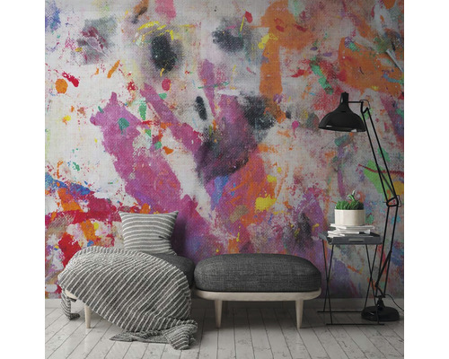 Pièce avec décor mural coloré, fauteuil, tabouret et lampadaire