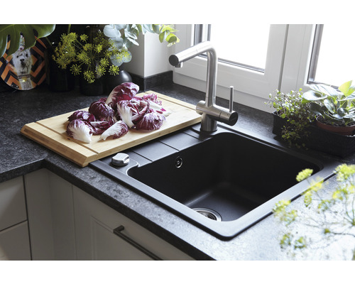 Évier de cuisine avec robinetterie, planche à découper et radicchio sur le plan de travail