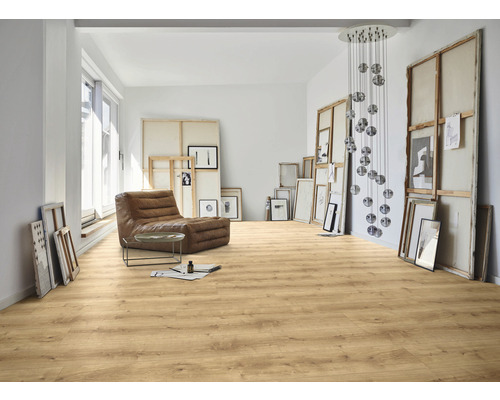 Heller Raum mit Laminatboden, Sessel und Kunstobjekten