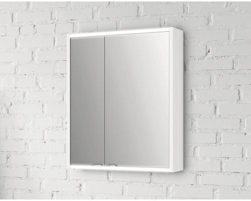 Armoire de toilette blanche à deux portes devant un mur de briques