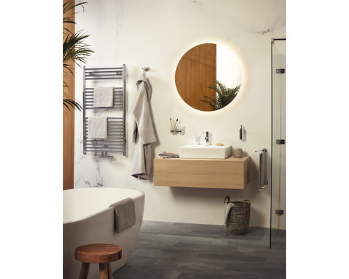 Helles Badezimmer mit Badewanne, Waschtisch, Spiegel und Handtuchwärmer