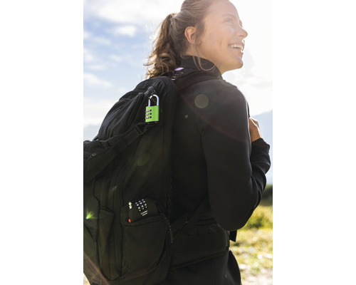 Femme avec sac à dos et cadenas à combinaison vert