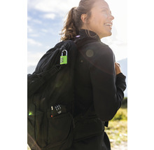 Femme avec sac à dos et cadenas à combinaison vert