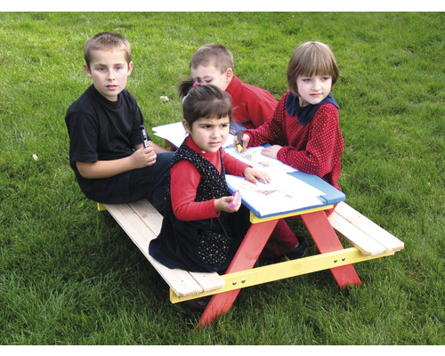 Kinder sitzen an einem Picknicktisch im Freien und malen.