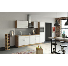 Cuisine lumineuse avec armoires modernes, évier, hotte aspirante et table à manger.