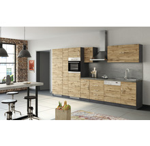 Helle Küche mit Holzfronten, Spüle, Herd und Esstisch mit Barhockern.