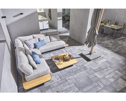 Espace extérieur avec canapé d''angle, table, foyer, parasol et table de jardin avec chaises sur pavés