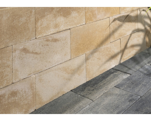 Wand aus Betonsteinen und Boden aus Pflastersteinen