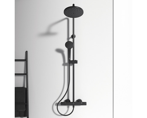 Schwarze Duscharmatur mit Kopfbrause und Handbrause an einer Wand montiert.