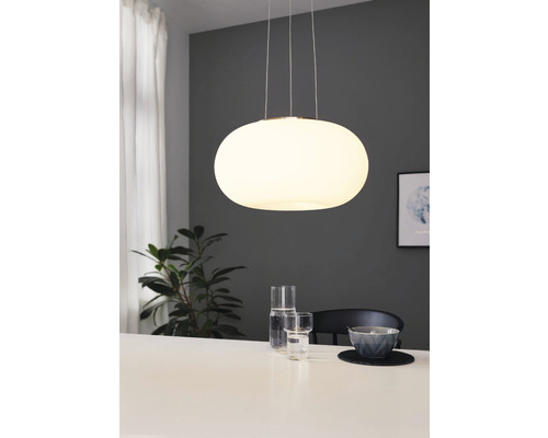 Lampe suspendue ovale en verre au-dessus d''une table à manger