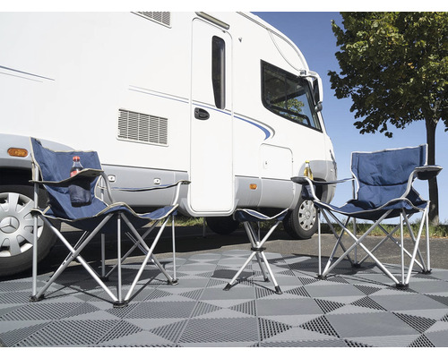 Scène de camping avec deux chaises de camping, un marchepied et un camping-car.