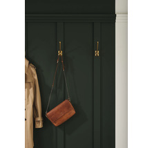 Garderobe mit Jacke und Tasche an goldenen Haken
