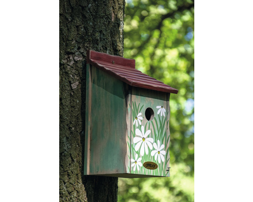 Vogelhaus mit Gänseblümchenmuster an einem Baum