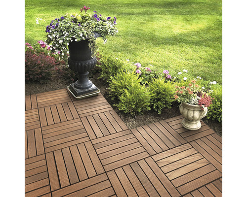 Dalles de terrasse posées dans un jardin avec des fleurs dans des jardinières.